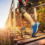 Turista kráča po lesnom chodníku v nových topánkach počas skúšobnej prechádzky
