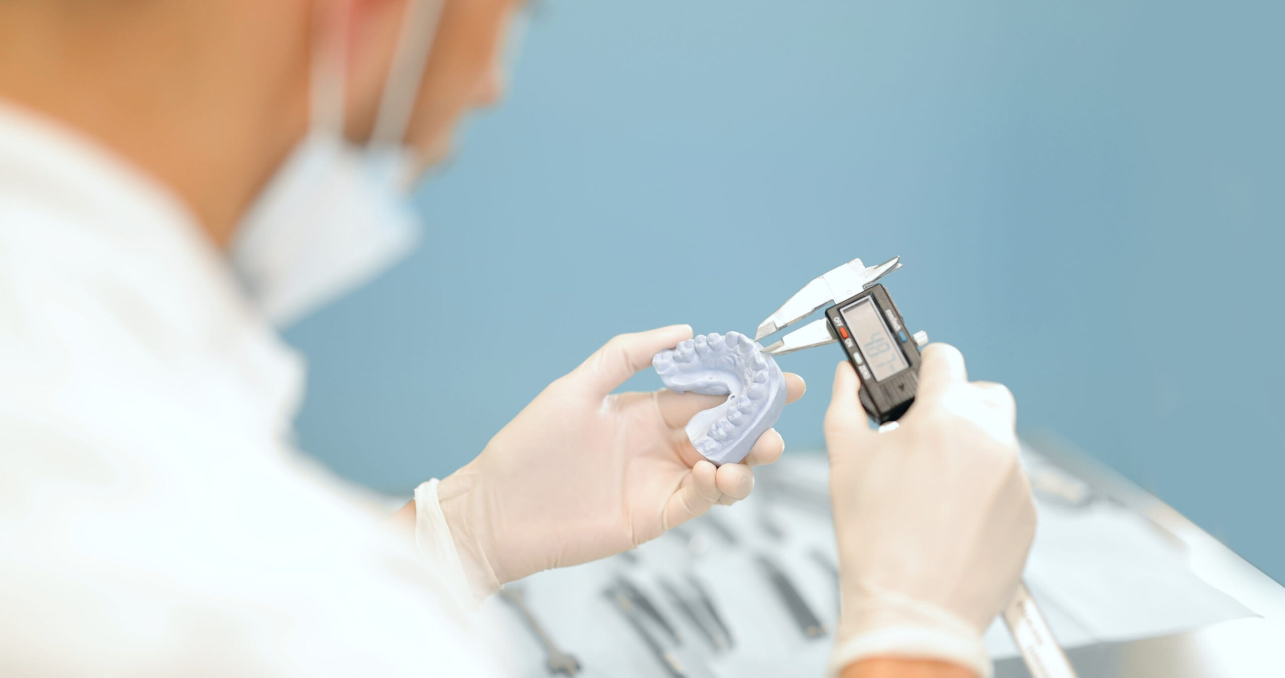 Usmievavý starší muž s dokonalou hornou a dolnou zubnou náhradou po estetickom zákroku u stomatológa.